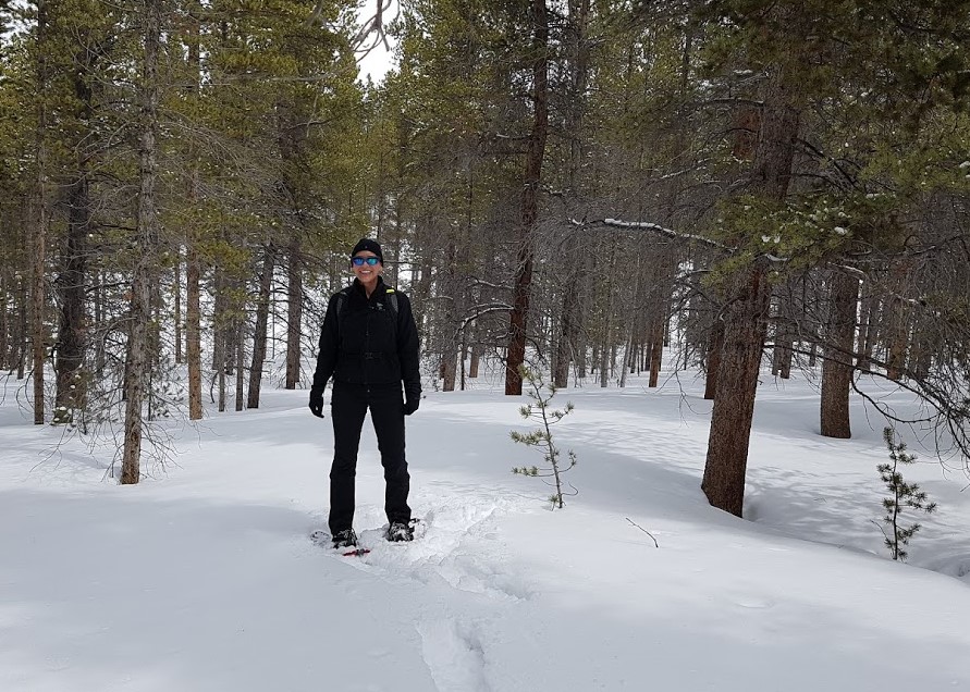 image of Catherine in trees in snowshoes.